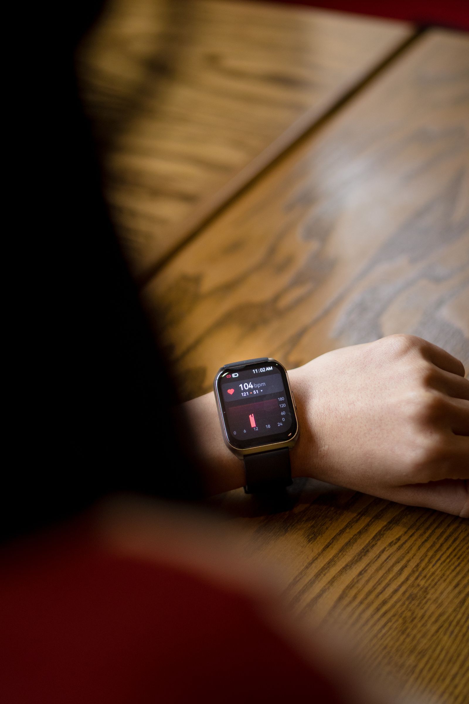 Close-up of a smartwatch on a wrist displaying a live heart-rate reading.